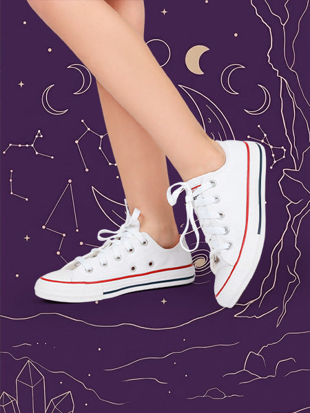 Zoom in a niña utilizando tenis converse rosas en un fondo rosa